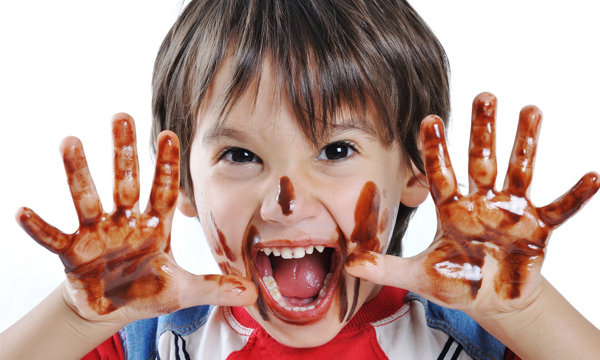 little boy with sticky hands from eating sweet treats